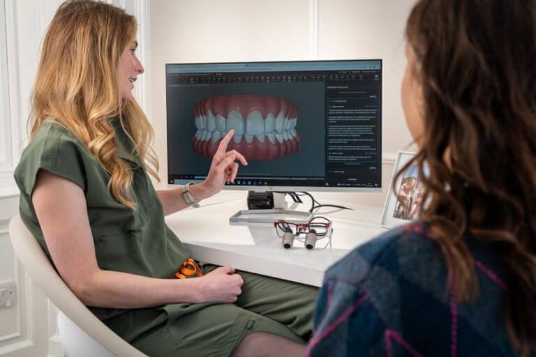 Dental implant process Rotherham. Photo of a dentist with a patient pointing to a screen talking through a procedure.